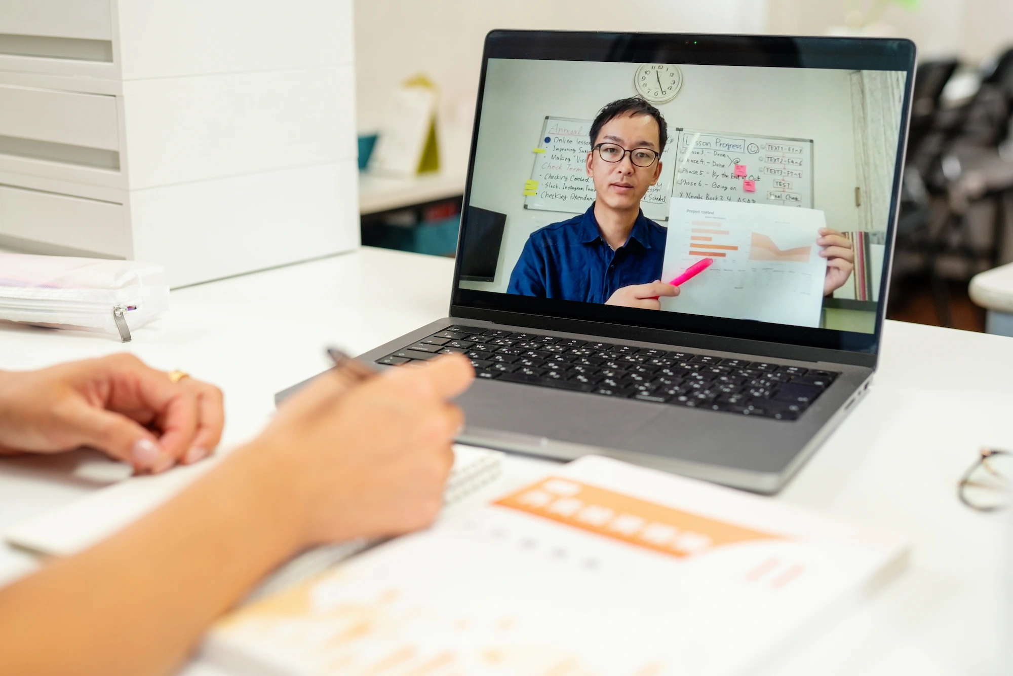 tutor showing his student a graph, while presenting from a web meeting