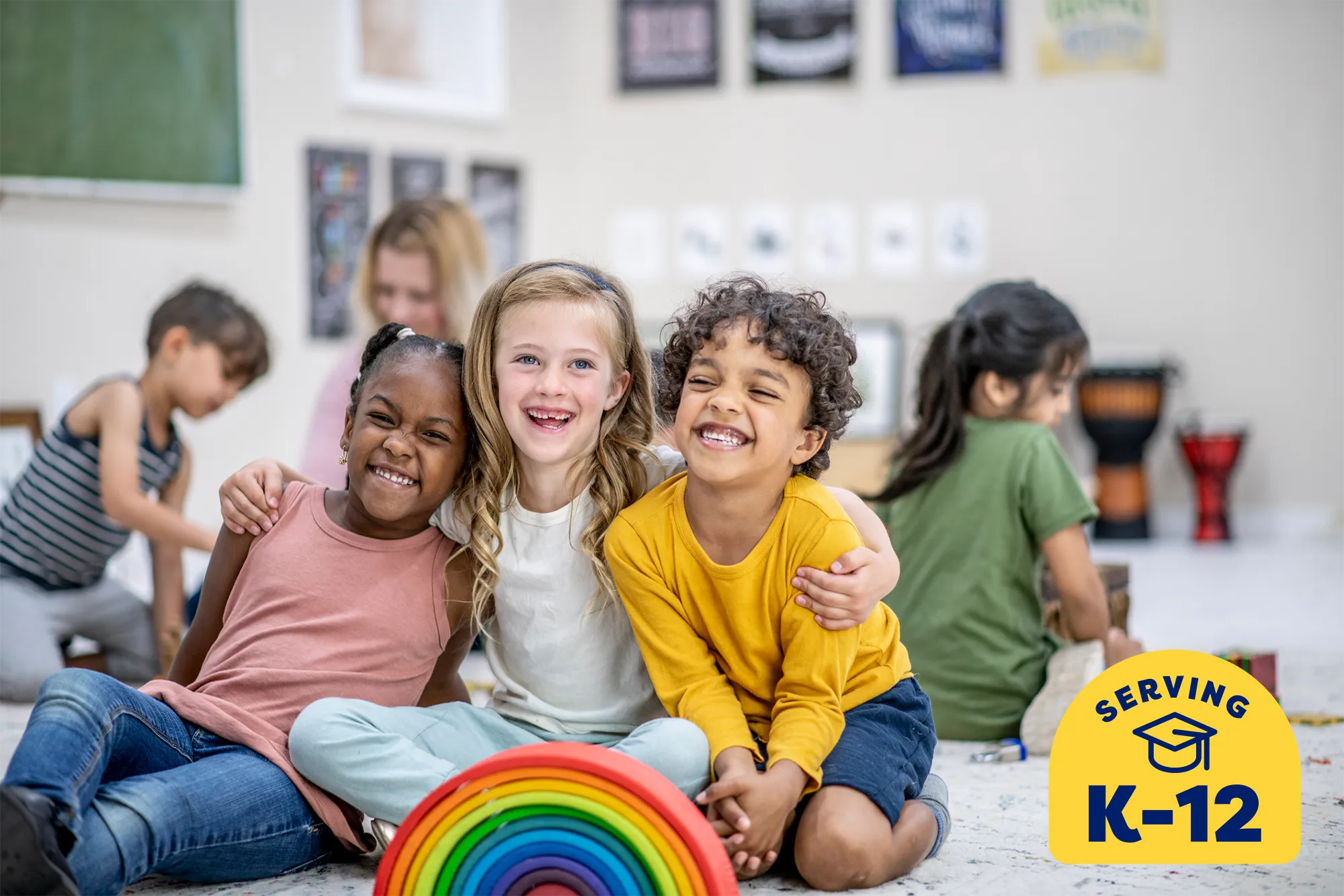 3 elementary school kids hugging and laughing in a classroom