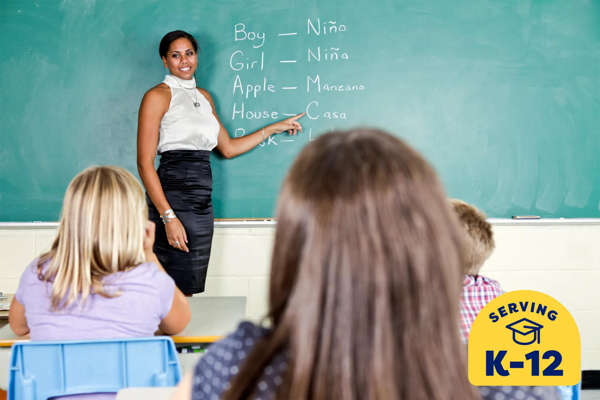 Spanish teacher at the chalkboard teaching her students the Spanish word for "house"