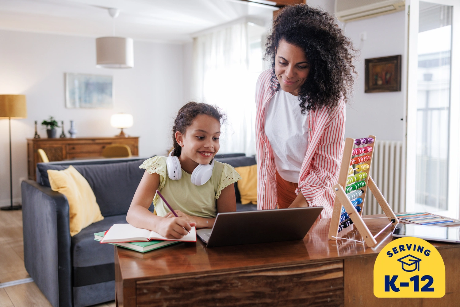 young home schooled student learning online with her mom's help